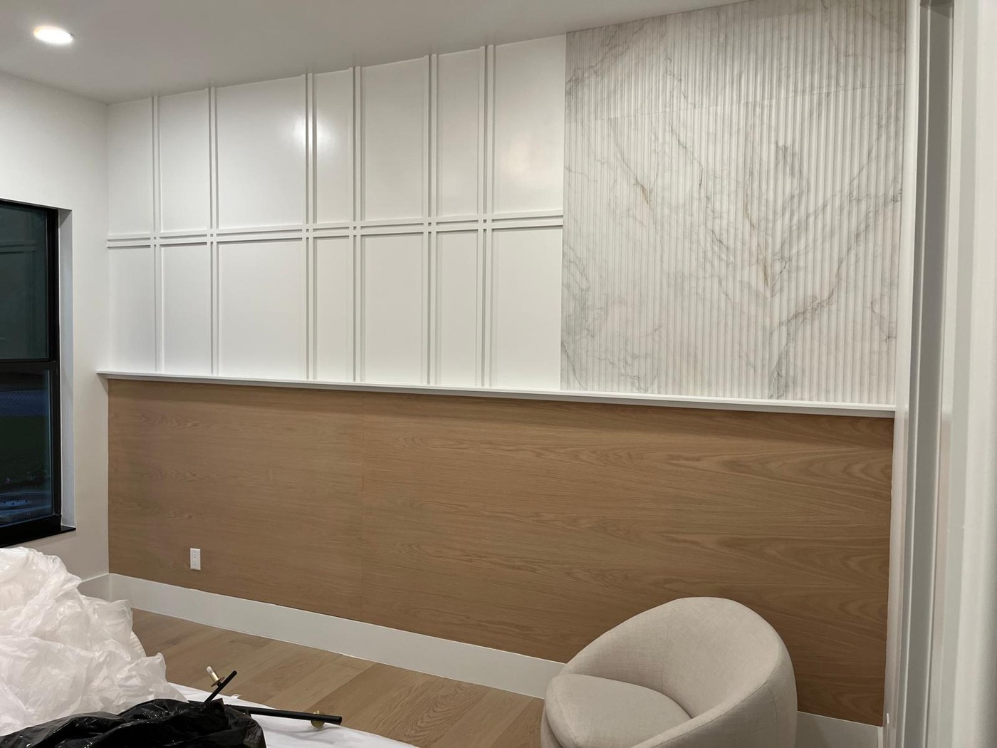 Custom accent wall — wainscoting, fluted marble and oak panels