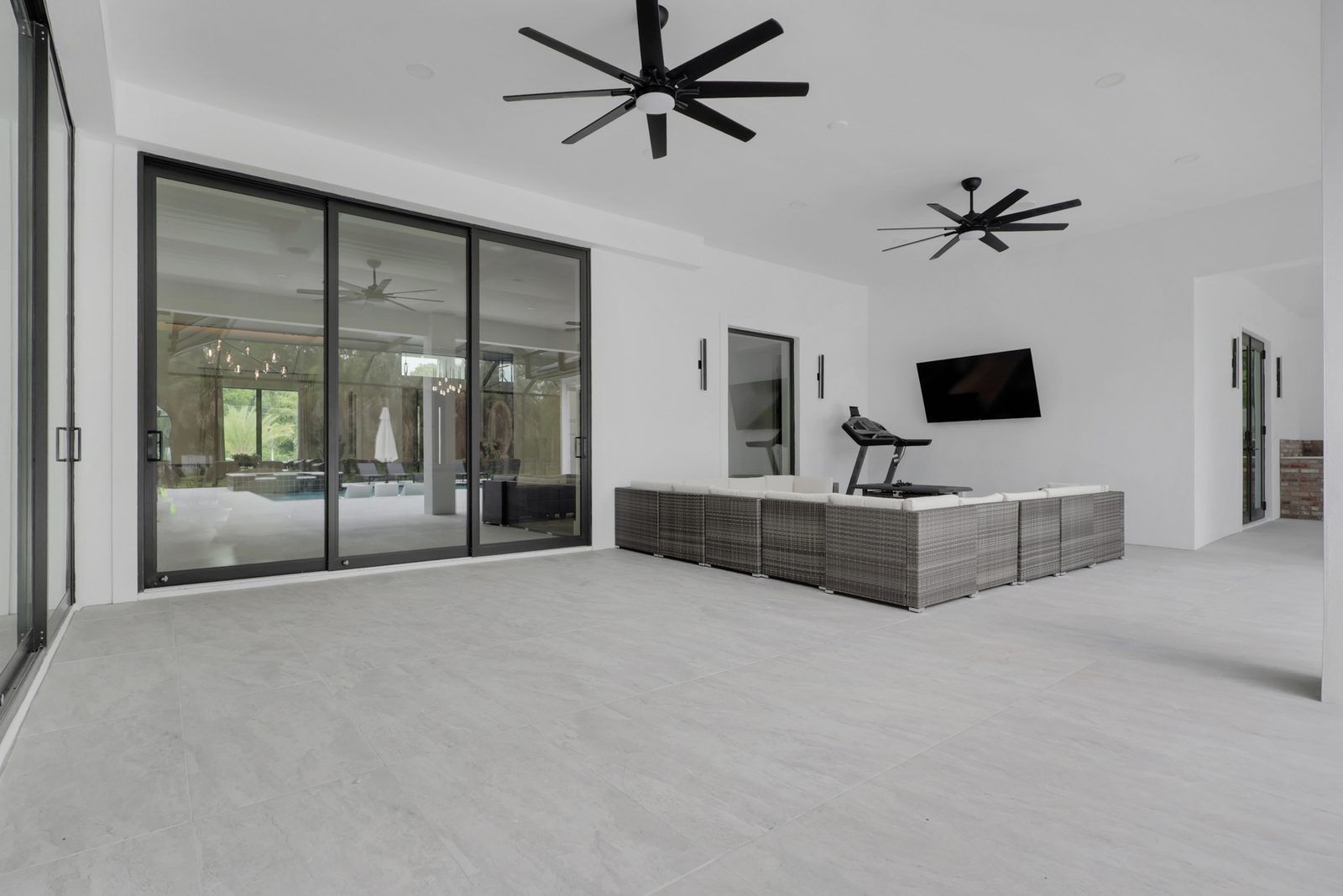 Covered outdoor living area set up for a TV and family seating in Naples, Florida