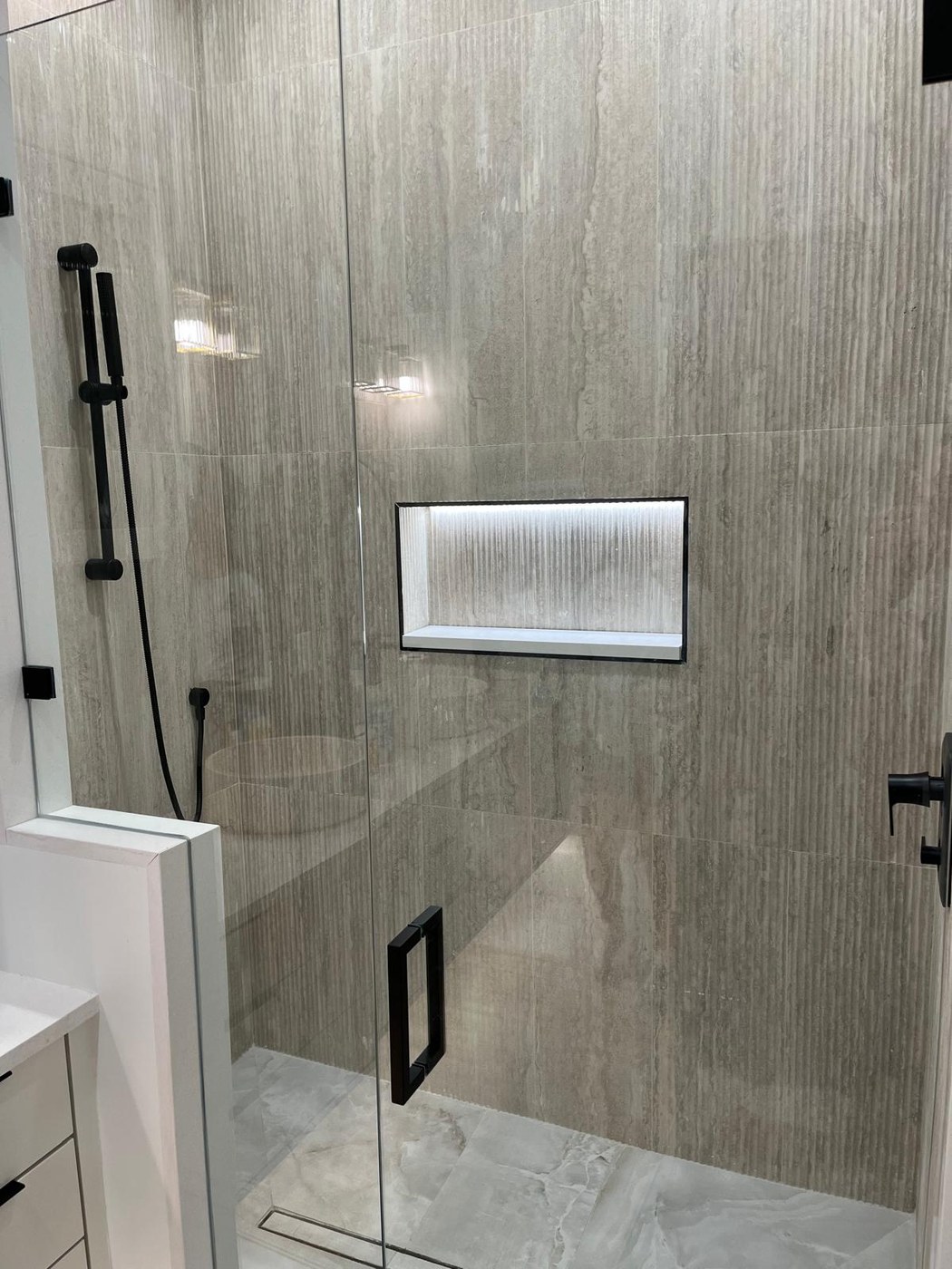 Frameless glass shower with fluted tile niche