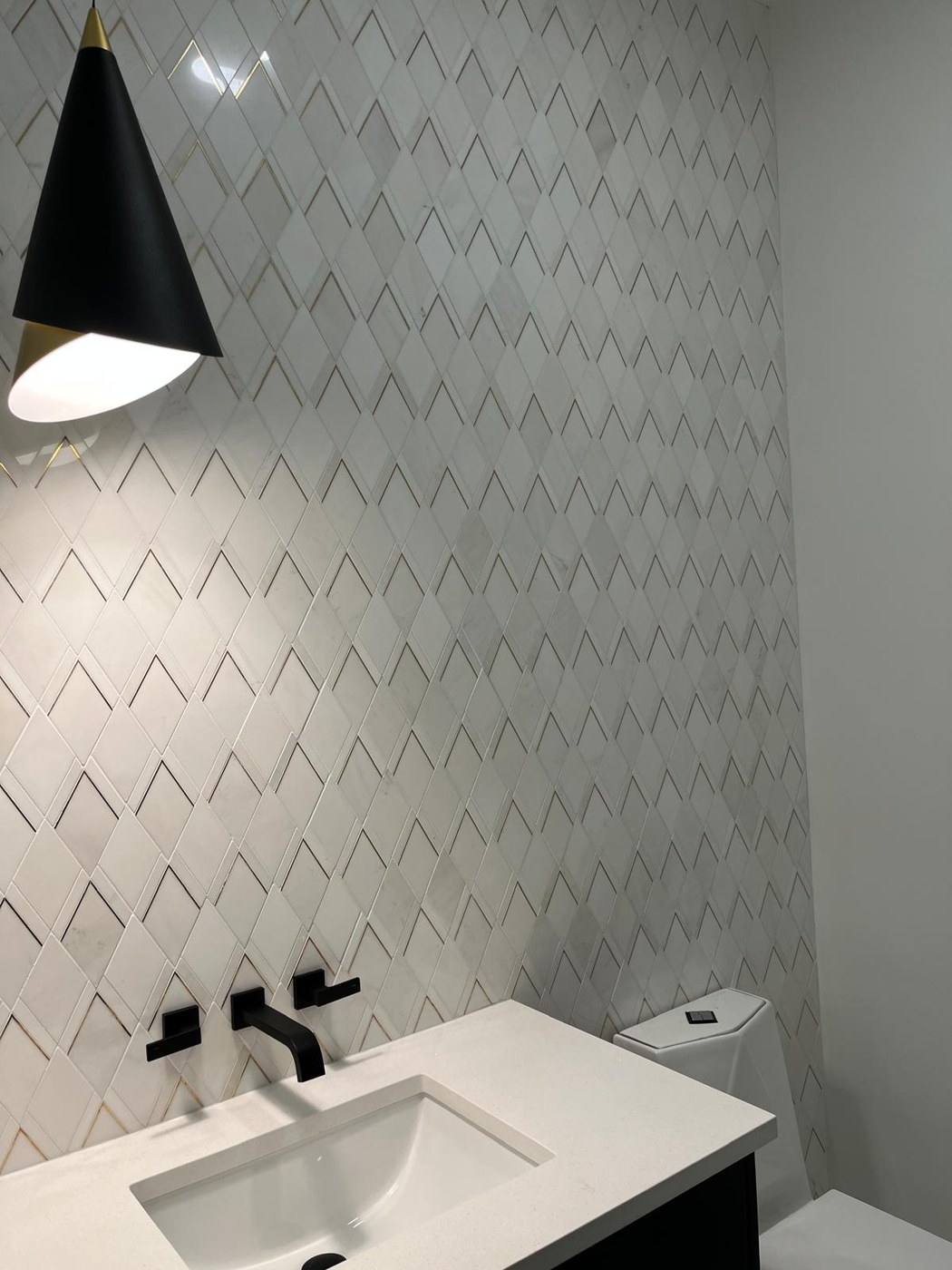 Powder room with chevron marble tile and black fixtures