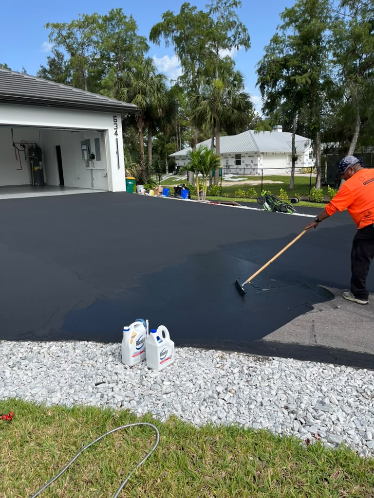 Fresh bound wear layer being applied to a driveway, restoring surface protection over sound existing pavement